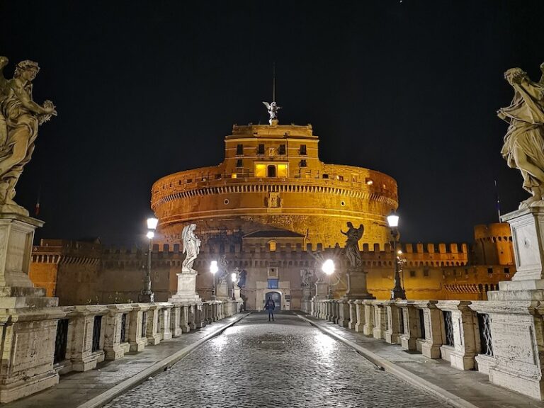 View of Bernini's Bridge of angels looking towards Castel Sant'Angelo at night illuminated