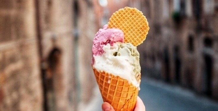 Ice-cream gelato in a cone with an Italian street in the background