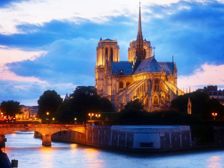 notre dame glistens in a paris twilight over the river seine