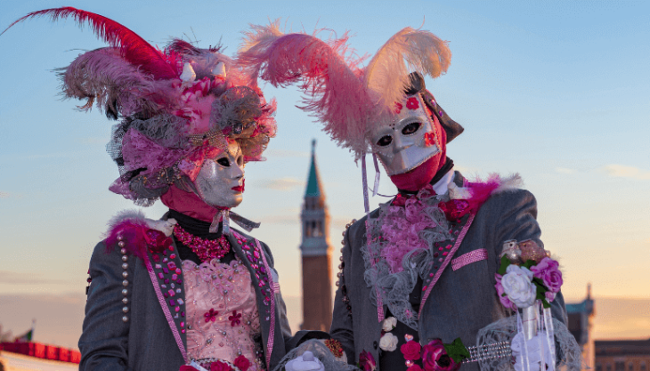 Carnival Venice two revellers dressed in pink wearing Venetian masks